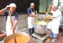 Due pentoloni di polenta: i volontari all'opera